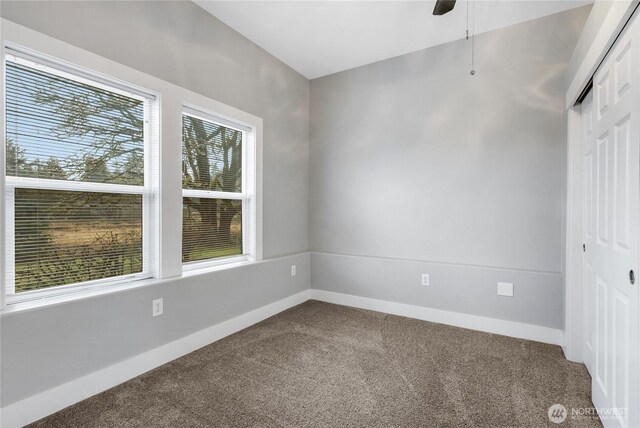 carpeted empty room with baseboards and a ceiling fan