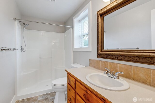 bathroom with toilet, walk in shower, decorative backsplash, and vanity