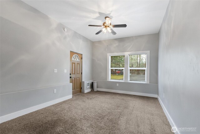 spare room with carpet, baseboards, and ceiling fan