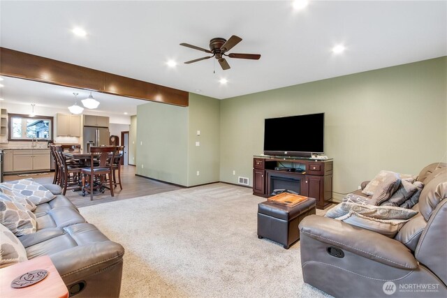 living room with light carpet, baseboards, a ceiling fan, and recessed lighting