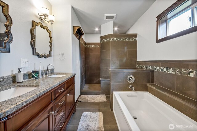 full bath featuring double vanity, visible vents, a sink, tile patterned flooring, and a bath