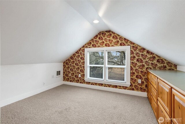 additional living space with lofted ceiling, visible vents, carpet floors, and baseboards