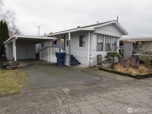 manufactured / mobile home featuring driveway and a carport