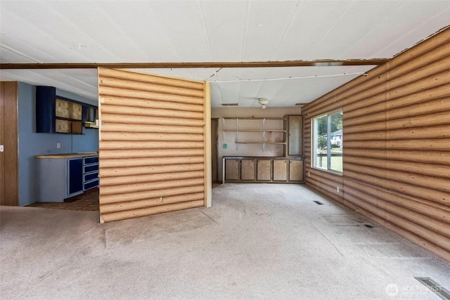 unfurnished living room with carpet and log walls