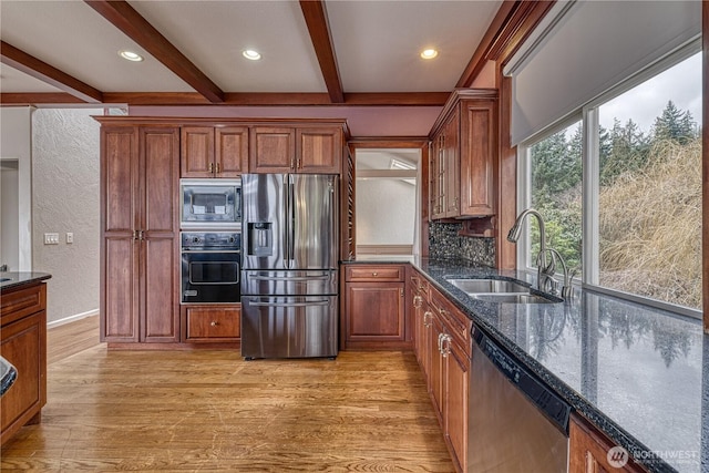 kitchen with stainless steel appliances, beamed ceiling, a sink, and light wood-style flooring