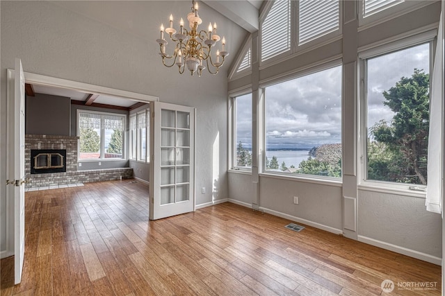 unfurnished living room with baseboards, light wood-type flooring, and a brick fireplace