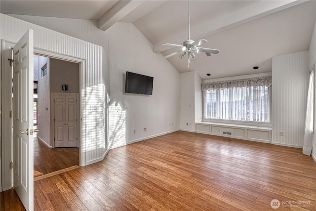 interior space featuring lofted ceiling with beams, light wood finished floors, visible vents, and a ceiling fan