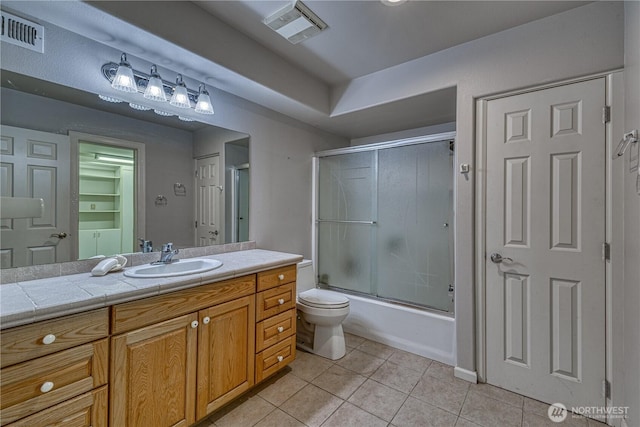 bathroom with enclosed tub / shower combo, vanity, visible vents, and tile patterned floors