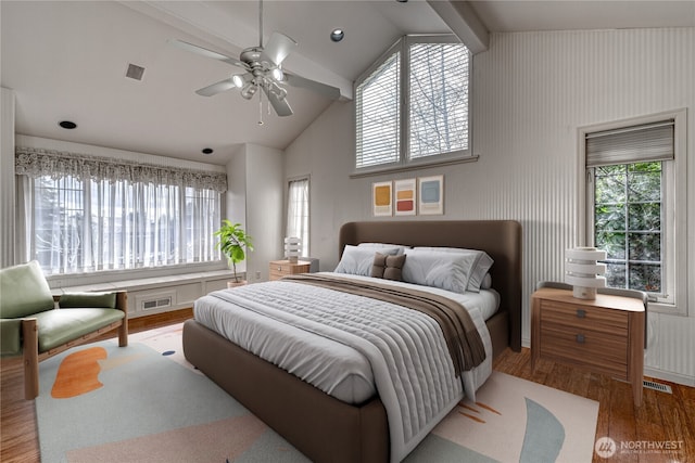 bedroom featuring high vaulted ceiling, wood finished floors, and visible vents