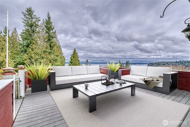 deck featuring a water view and an outdoor living space