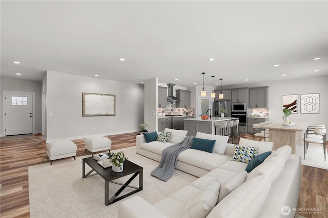 living room with light wood-style flooring, baseboards, and recessed lighting