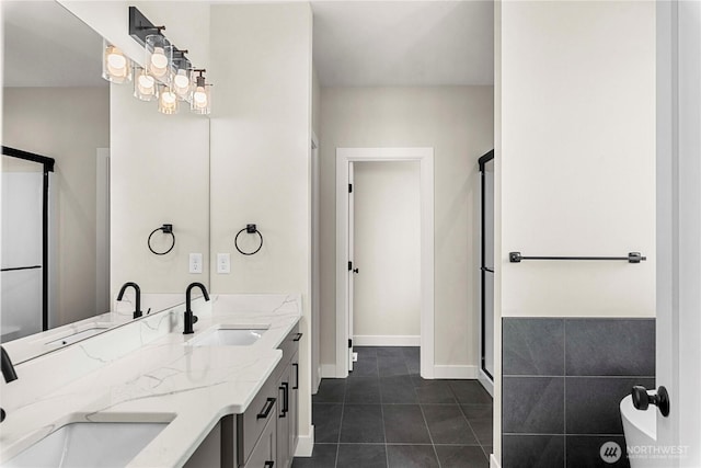 full bathroom with tile patterned flooring, a sink, baseboards, and double vanity