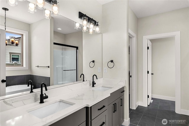 full bathroom with double vanity, a shower stall, a sink, and tile patterned floors