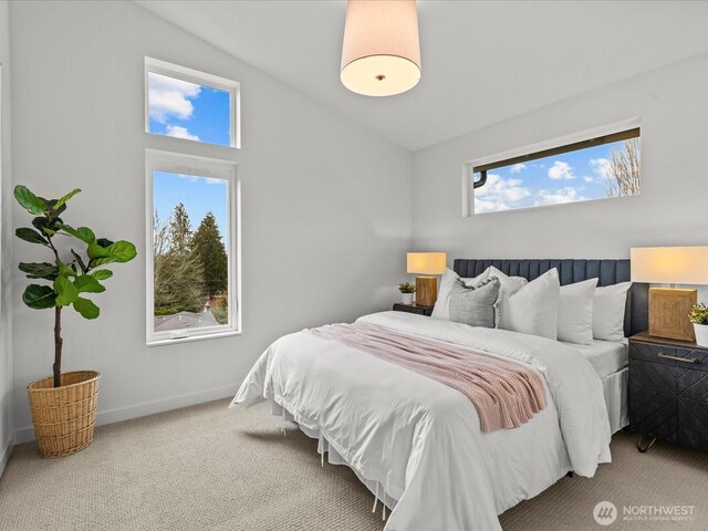 carpeted bedroom with lofted ceiling and baseboards