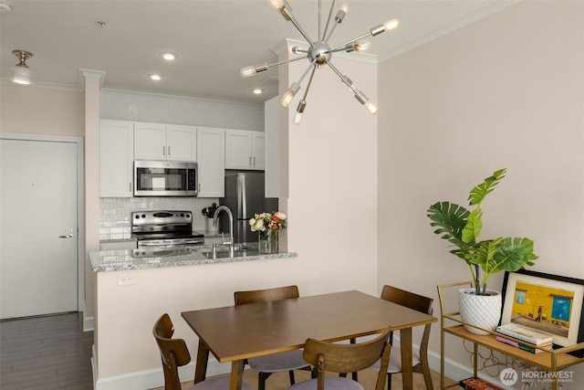 dining space featuring baseboards, ornamental molding, dark wood-type flooring, a notable chandelier, and recessed lighting
