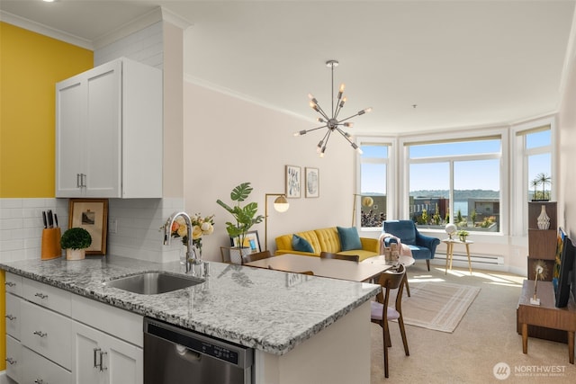 kitchen featuring a sink, white cabinets, ornamental molding, stainless steel dishwasher, and light stone countertops