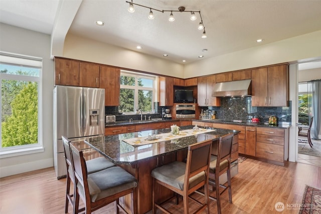 113 Northridge Dr, Ridgefield, WA 98642 - kitchen featuring appliances with stainless steel finishes, a sink, backsplash, a kitchen bar, and under cabinet range hood