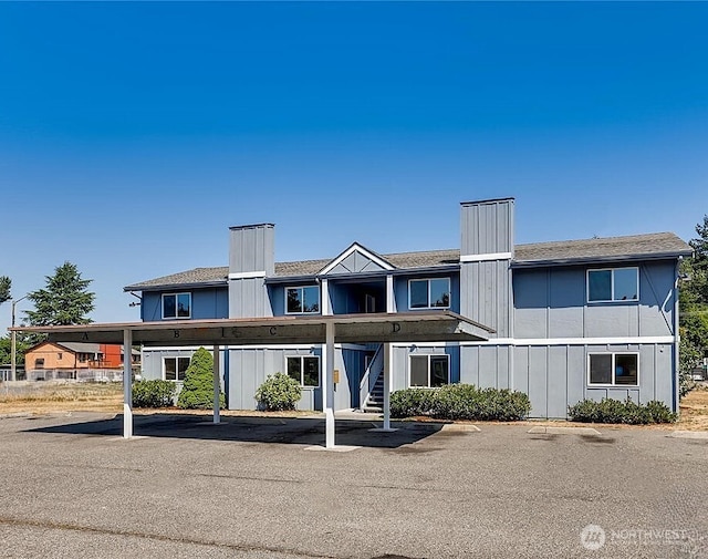 view of property featuring covered parking and stairway