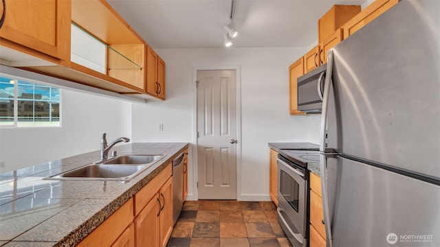 300 110th Ave NE Unit 605, Bellevue, WA 98004 - kitchen featuring appliances with stainless steel finishes, a sink, tile countertops, dark stone finish flooring, and rail lighting