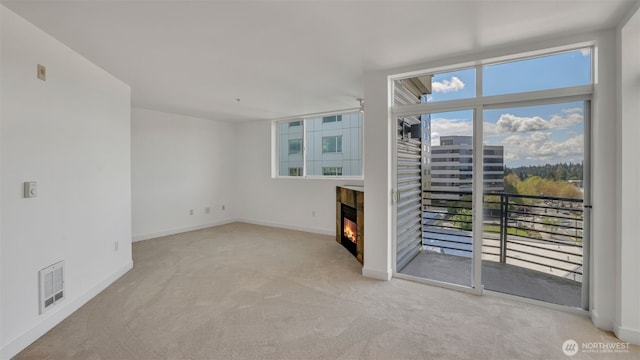 300 110th Ave NE Unit 605, Bellevue, WA 98004 - spare room featuring carpet, a glass covered fireplace, and baseboards