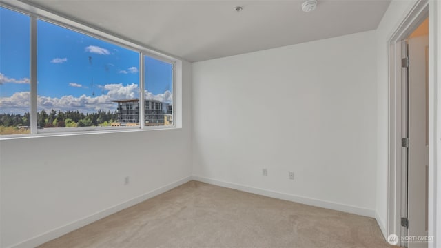 300 110th Ave NE Unit 605, Bellevue, WA 98004 - unfurnished room featuring a smoke detector, light colored carpet, baseboards, and fire sprinkler in ceiling