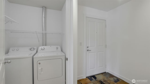300 110th Ave NE Unit 605, Bellevue, WA 98004 - laundry room with washing machine and dryer, baseboards, and dark stone finish floors