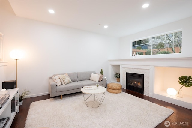 living room with a premium fireplace, dark wood finished floors, and recessed lighting