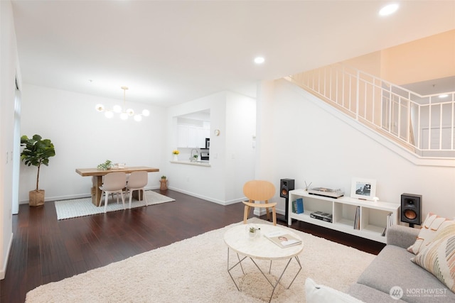 living area featuring baseboards, stairway, dark wood-type flooring, a chandelier, and recessed lighting