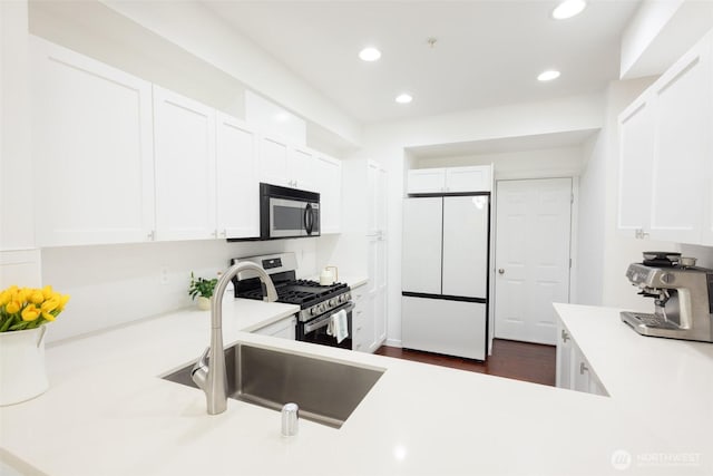 kitchen with recessed lighting, light countertops, appliances with stainless steel finishes, white cabinetry, and a sink