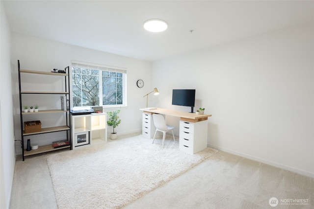 unfurnished office featuring light carpet and baseboards