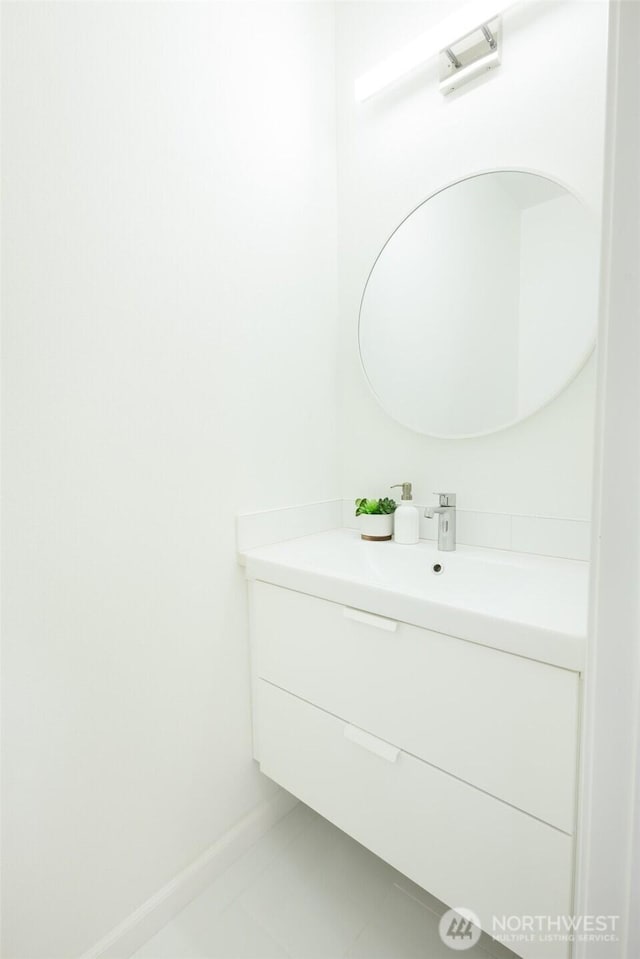 bathroom with tile patterned floors, baseboards, and vanity