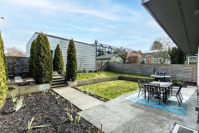 view of yard featuring a patio area, a fenced backyard, and outdoor dining area