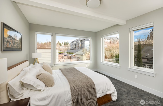 carpeted bedroom featuring beamed ceiling and baseboards