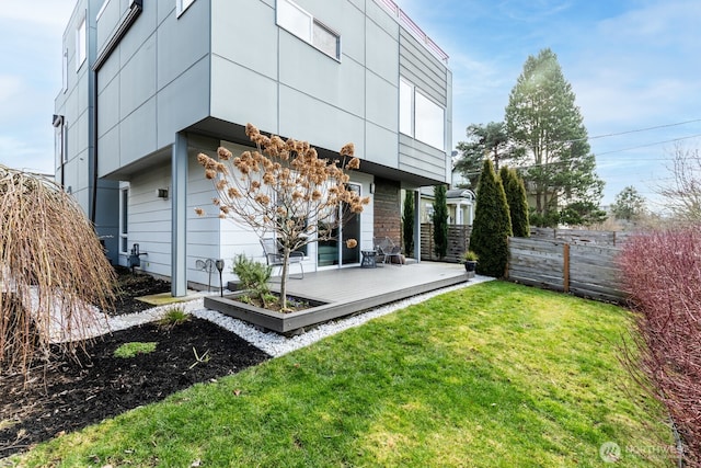 back of house with a lawn, fence, and a wooden deck