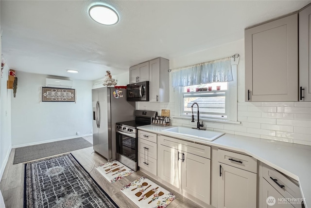 kitchen featuring a sink, backsplash, stainless steel appliances, and light countertops