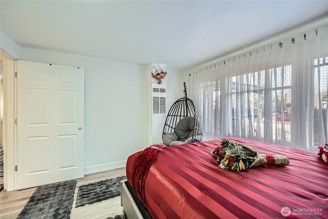 bedroom with light wood finished floors and baseboards