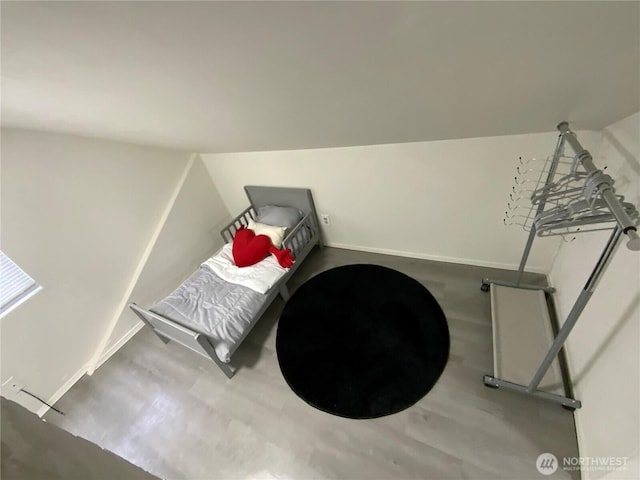 bedroom featuring vaulted ceiling, baseboards, and wood finished floors