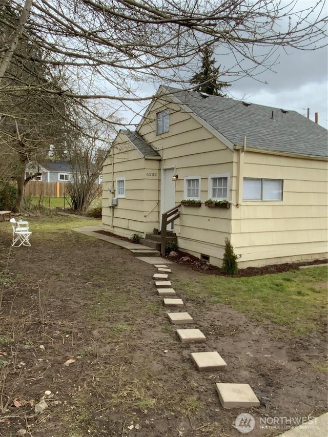 back of property featuring roof with shingles