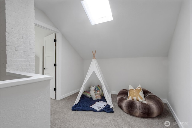 playroom with baseboards, lofted ceiling with skylight, and light colored carpet