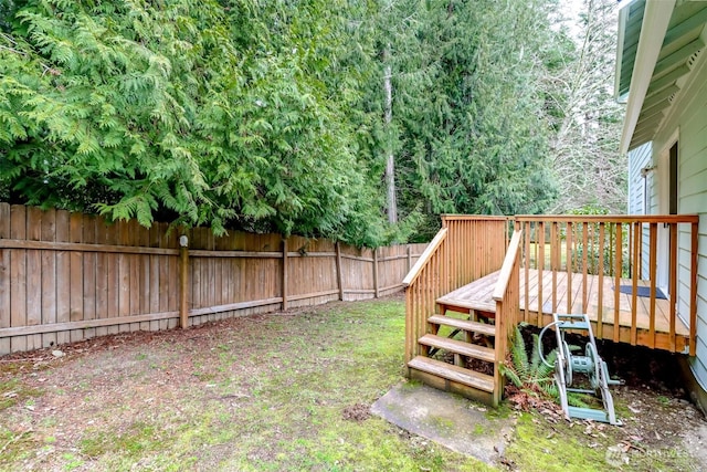 view of yard with a fenced backyard, stairs, and a deck