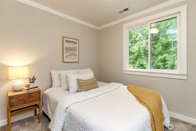 carpeted bedroom with visible vents, baseboards, and crown molding