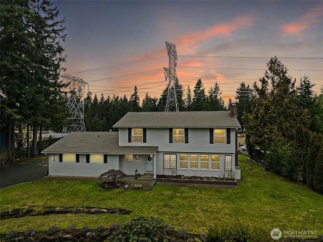 view of front of home featuring a front lawn and a chimney