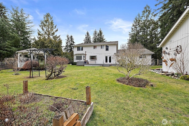 view of yard featuring a deck, a vegetable garden, and a pergola