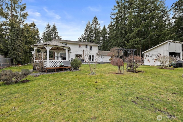 back of property featuring a yard and a gazebo