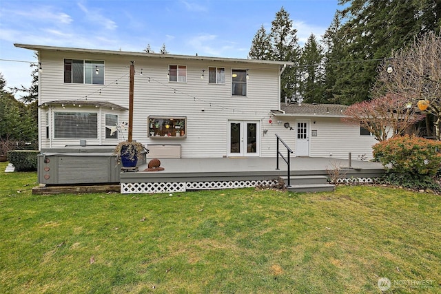 rear view of property with french doors, a lawn, a hot tub, and a wooden deck