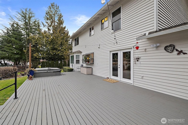 wooden deck with french doors and a covered hot tub