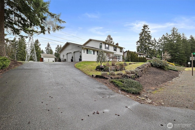 view of front of house with a garage, driveway, and a chimney