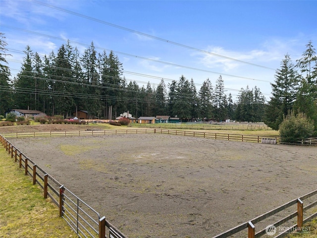 view of yard featuring a rural view, an enclosed area, and fence