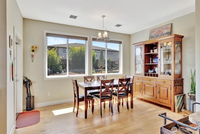 dining space featuring a healthy amount of sunlight, light wood-style floors, and visible vents