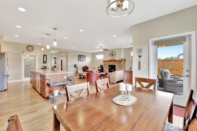 dining space featuring a wealth of natural light, a fireplace, light wood-style flooring, and recessed lighting